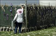 Emily Miriam Gallegos puts crosses on a fence outside a Border Patrol station near San Diego. The crosses symbolize migrants who died attempting to cross the border into the United States. A Republican-led House panel held a hearing on immigration Wednesday at the station.