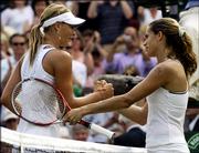 Amelie Mauresmo, right, meets Maria Sharapova at the net. Mauresmo defeated Sharapova in the Wimbledon semifinals Thursday.
