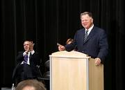 Clay Blair, chairman of the Kansas Bioscience Authority, draws applause from Kansas State University President Jon Wefald, left, as Blair introduces bioscience authority officer Bill Sanford on Thursday during a ceremony at Olathe Northwest High School in Olathe. Officials detailed plans for a partnership that will give K-State 40 acres for research and academic operations on College Boulevard.