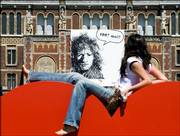 A woman sits in front of a Rembrandt poster at the Rijksmuseum in Amsterdam, Netherlands. The Dutch celebrate the 400th anniversary of Rembrandt's birth on Saturday. Rembrandt's work and his life are open to the public as never before during the yearlong festival "Rembrandt 400," as a series of spectacular exhibitions highlight different aspects of his work.