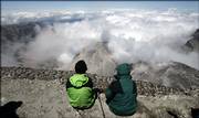 Two members of a news media climbing party sit Thursday on the crater rim of Mount St. Helens. The volcano is scheduled to reopen for climbers on a permit-only basis July 21 after being closed since volcanic activity resumed on the mountain in September 2004.