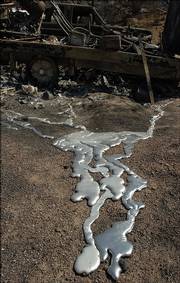 Melted metal drips from a burned-out truck destroyed by a wildfire in Morongo Valley, Calif. Fires in California have destroyed more than 50 homes and killed at least one person.
