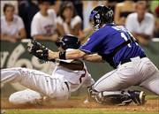 Boston's Willie Harris slides into home with what proves to be the winning run on a sacrifice fly by Manny Ramirez in the eighth inning. The run ahead of the tag of Royals catcher John Buck, right, lifted the Red Sox to a 5-4 victory Monday in Boston.