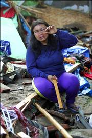 An Indonesian woman who lost her 6-year-old son in Monday's tsunami weeps as she sits on the rubble of a house in Pangandaran, Indonesia. Desperate villagers and soldiers dug through destroyed homes and hotels today looking for survivors of a tsunami on Indonesia's Java island, as the death toll passed 200.