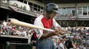 Buck O'Neil swings the bat to warm up before playing in a minor league all-star baseball game Tuesday in Kansas City, Kan. O'Neil, a former Negro Leagues player, signed a one-day contract with the T-Bones, making him the oldest professional player at 94.