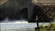 Perry resident Frank Tibbet casts his line out into the Delaware River early Wednesday evening just south of where the Perry Lake spillway connects with the Delaware and eventually leads to the Kansas River. The Army Corps of Engineers at Perry Lake was ordered to open the sluice gates to send water to the Kansas River and then into the Missouri River in an effort to boost water levels to help barge traffic.