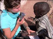 Ellie Ott, a Lawrence native who visited Africa for two months this summer, sits with a child named Kianda at a refugee camp in Zambia. Kianda and other children at the camp were curious about Ott, her camera and other college students who traveled to the camp to improve the library, Ott said.