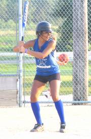 Master Hitter Jasmyn Turner waits at home plate and smiles at comments from her teammates in the dugout on July 18 at Broken Arrow Park. The Master Hitters lost 12-11 to The Flash in both team's last game of the season in their U14 Lawrence Girls Fast Pitch match-up.