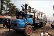 Police stand on top of a truck that was carrying election papers and was set on fire by opposition party supporters Saturday in the streets of Mbuji Mayi, Congo. On Saturday, opposition supporters in the central city of Mbuji Mayi attacked a truck carrying voting materials, setting it ablaze as they shouted "Nobody is going to vote!" and stoned police who fired tear gas to try dispersing them.