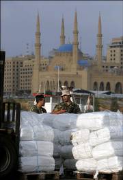 Lebanese soldiers talk as U.S. Navy members unload the humanitarian supplies delivered by the US HSV 2 Swift on Saturday at the port of Beirut, Lebanon. USAID commodities dispatched about 20,000 blankets, 1,000 tarps and seven emergency medical kits in Lebanon.