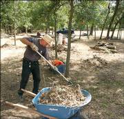 Gerry Fonseca clears brush Thursday from a 5-acre lot in Crawford, Texas. The lot was bought with insurance money Cindy Sheehan received after her son was killed in Iraq. Fonseca, also a war protester, was Sheehan's agent in the purchase.