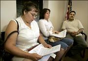 Soledad Salas, left, Maria Arreola, center, and Aristeo Arreola look over paperwork while waiting to meet with a counselor during a recent citizenship workshop at El Centro in Kansas City, Kan. Activists believe thousands of new Hispanic voters could shift the political tide from conservative to liberal.