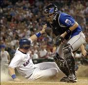 Texas Rangers' Hank Blalock, left, scores against Kansas City Royals catcher John Buck. Blalock scored on a single by Mark DeRosa on Sunday in Arlington, Texas.