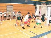 Former Kansas University All-American Nick Collison, left, leads a dribbling drill at his basketball camp. Collison's camp took place July 25-28 at Wichita Collegiate High.