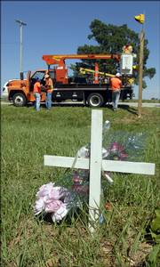 workers with the Kansas Department of Transportation set up stop signs and flashing lights at Baldwin Junction, although the new signals were taken down about an hour later. Rumble strips must be installed before the signs can be used. They worked Friday near a roadside memorial for two young women recently killed at the intersection of U.S. highways 56 and 59.
