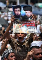 An Iraqi boy holds a portrait of Shiite cleric Muqtada al-Sadr and Hezbollah's Sheik Hassan Nasrallah. Thousands of Shiites filled the streets of Baghdad's Sadr City to attend a rally in support of Lebanon after Friday prayers.
