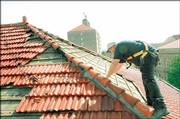 Darrick Oden, with Diamond Everley Roofing, Lawrence, surveys damage to roof tiles on Dyche Hall in this March 15 file photo. More than 70 buildings on Kansas University's campus were damaged in a March 12 microburst.