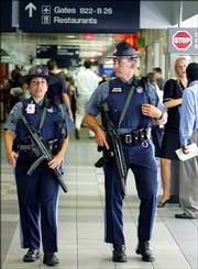Massachusetts State police patrol with automatic weapons inside a terminal at Logan International Airport in Boston, Thursday, Aug. 10, 2006. The response to the terrorist threat announced Thursday produced long lines at airports as security officials scrambled to put new measures in place and passengers faced perplexing new restrictions, including a ban on carrying liquids onto aircraft.