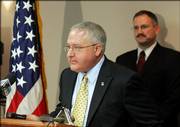 xU.S. Atty. Eric Melgren speaks at a news conference about grand jury indictments of Bob Eisel Powder Coatings and some of its employees. The owner and two employees of the Wichita company were charged Thursday in a 28-count indictment of knowingly hiring illegal immigrants and helping them obtain false identification documents. Kelly Bloyer of the Social Security Administration is at right.