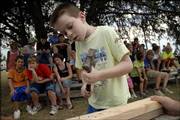 Levi Smith, 8, races against the clock to hammer three nails into a piece of wood during the Old-Time Farm Skills Contest at the Vinland Fair. Thursday was the first day of the 99th fair in Vinland, which is southeast of Lawrence. The fair continues through Saturday.