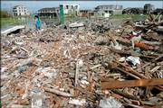 A woman stands among the debris left after her house was struck Friday by Typhoon Saomai, in Heweiyang village, in China's Zhejiang province. The death toll from the most powerful storm to strike China in five decades rose to at least 104 Friday, with another 190 people missing, after Typhoon Saomai destroyed thousands of homes and capsized ships.