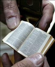 Gene S. Albert Jr. displays a Bryce Bible, the smallest printed Bible, at the Christian Heritage Museum.