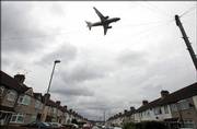 A British Airways aircraft nears London's Heathrow Airport as it flies over an urban estate near the airport Saturday as disruption caused by an alleged terrorist threat continues.
