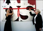 Sandra Oh, left, and Olympia Dukakis cut the ribbon on the AIDS statue to launch the XVI International AIDS Confer-ence on Saturday in Toronto. Thousands of AIDS experts, activists and politicians streamed into Toronto on Saturday for the world's largest conference devoted to combating the disease.
