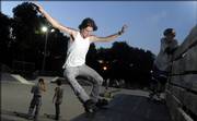 Skyler Farley, 16, Lawrence, above, slides along the railing of the halfpipe feature last week at the Lawrence skate park in Centennial Park. The city on Tuesday approved $50,000 to add new skating features at the park.