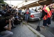 Boy George, right, who was born George O'Dowd, is photographed by the press as he sweeps a curb in New York. The one-time Culture Club singer was ordered to spend five days working for the Department of Sanitation after pleading guilty in March to falsely reporting a burglary at his lower Manhattan apartment. The officers who responded found cocaine instead.