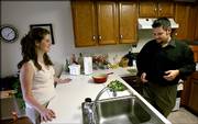 Jennifer Quint and her brother Jason prepare dinner at their home in Apopka, Fla. The Quints bought the house together this summer. They plan to rent a third room to a friend to help with expenses and then sell in about five years to buy their own places.