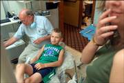 Dr. F. Robert Burns, a dentist in Weston, Mo., gets ready to extract baby teeth from Ihar Melnikau, 9. Ihar is participating in a program that brings Belarusian children to the area for recuperative stays after the 1986 explosion of the Chernobyl Nuclear Power Plant in Ukraine.