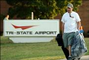 Wayne Bloss, of Huntington, W.Va., carries his suitcases out of the Tri-State Airport in Ceredo, W.Va., after the airport terminal was evacuated Thursday. Bloss missed his flight to Orlando, Fla., earlier in the day and was told he could return later to retrieve his luggage. Two bottles of liquid found in a woman's carry-on luggage twice tested positive for explosives, a Transportation Security Administration spokeswoman said. But later tests found no explosives in the bottles.