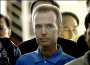 American John Mark Karr is surrounded by Thai and American officers as he is led out of a detention center Thursday in Bangkok, Thailand. The former schoolteacher has been arrested in the slaying of 6-year-old JonBenet Ramsey.
