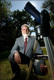 Astronomer Khalid Shaukat poses with a telescope at his home in Silver Spring, Md. He uses astronomical calculations to determine the Islamic calendar, so that all North American Muslims can celebrate holidays on the right day.