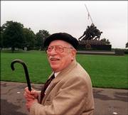 In a file photo with the Iwo Jima Memorial in the background, Pulitzer Prize-winning photographer Joe Rosenthal poses for photographers in 1995 in Arlington, Va., during a ceremony honoring photographers who lost their lives covering military conflicts around the world. Rosenthal won a Pulitzer Prize for making the photo that the Iwo Jima Memorial is modeled after. Rosenthal died Sunday at age 94.