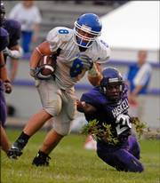 Peru State's Derek Darr breaks free from the grasp of HINU's Reginald Cazenave. Peru State cruised to a 27-6 victory Saturday in the season opener for both schools.