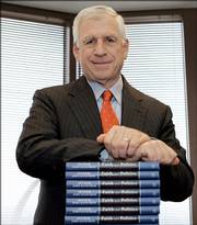Former U.S. Sen. John Danforth leans on a stack of his latest book, "Faith and Politics," in his St. Louis office.
