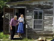 Like a true old-fashioned gentleman, Wes Jackson, left, Salina, offers Elaine Caldwell, Santa Barbara, Ca., his arm as Caldwell exits the historic home of Robert Hall Pearson at the Black Jack Battle site near Baldwin. Jackson, a decendent of Pearson's, and Caldwell, the great-great grandaughter of abolitionist John Brown, attended a meeting on Thursday at the Black Jack Battleground. The site, which some historians argue to be where the first fight of the Civil War occured, is currently undergoing changes that would turn the 40 acre farm into a park. If the organizers secure adequate funding, the Pearson home will be restored into it's original state as it appeared in 1885.