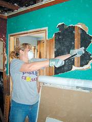 Karin Feltman, emergency room nurse at Lawrence Memorial Hospital, tears down the wall of a home in Long Beach, Miss., which was ravaged by Hurricane Katrina. Feltman helped with cleanup efforts in March. She said the home belonged to a 98-year-old resident whose parents had built it.