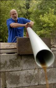 Gaylen Garinger, who lives at 937 E. 1000 Road southwest of Lawrence, checks a pump at an old well on his property while it pumps out some recent rain water. Garinger doesn't have rural water so once a week he or his wife goes to Hy-Vee Food Store to fill numerous 1 gallon water jugs.