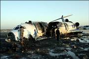 Iranian officials examine the site of a plane crash at the airport in the city of Mashhad, 620 miles northeast of Tehran. A jetliner blew a tire, skidded off a runway and caught fire while landing Friday, killing 29 people.