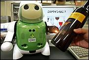 A "Winebot," or a robot that can taste, fires off a beam of infrared light from its left arm into a bottle of wine during a demonstration last month at a laboratory in Tsu, Japan. Researchers at NEC System Technologies and Mie University have designed the robot, a mechanical sommelier, that is able to identify dozens of different kinds of wine, cheeses and hors d&squot;oeuvres.