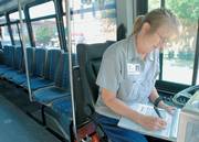 Lawrence Transit System driver Debra Rodman, Perry, logs mileage into her notebook. City officials are beginning to research energy-efficient buses now in development.