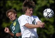 Free State defender Travis Everett, right, and Shawnee Mission South midfielder Christian Duke go up for a header. The Raiders beat the Firebirds, 4-1, Tuesday at FSHS.