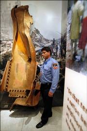 Ron Parker, a first responder on Sept. 11, 2001, and now a tour guide at ground zero, stands next to a twisted beam from the World Trade Center site in the new Tribute WTC Visitor Center. The center opened to private visits from victims' families, Sept. 11 survivors and recovery workers on Wednesday. It opens to the public on Sept. 18.