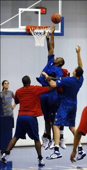 Kansas University freshman Darrell Arthur goes up for a putback attempt over the other Jayhawk big men. The Jayhawks held a blue-and-red scrimmage in mid-June at the Bill Self basketball camp in Horejsi Family Athletics Center.