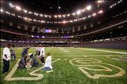 Grounds crews paint the end zones of the Louisiana Superdome on Monday. Next week, the New Orleans Saints will play the first game in their home stadium since it was damaged by Hurricane Katrina.