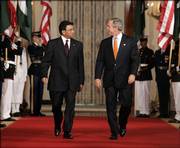 President Bush walks with Pakistan President Gen. Pervez Musharraf to the East Room at the White House on Friday to hold a news conference. Bush met Friday with Musharraf, who has claimed a U.S. official threatened an attack on his Muslim nation if it did not cooperate in the war on terror.