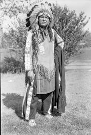 William "Lone Star" Dietz, wearing sioux indian regalia, poses in front of the Haskell Institute on Oct. 24, 1932. Dietz, according to a new biography, was raised by two white parents but believed he had Sioux blood. He is credited for inspiring the name of the Washington Redskins. Below, the cover of the St. Louis Globe-Democrat Sunday supplement on Jan. 26, 1908, portrays Dietz.